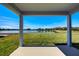 A covered patio space overlooking a lush backyard, lake and clear blue skies at 6807 162Nd Pl, Parrish, FL 34219