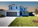 Charming two-story home boasts a manicured lawn, gray siding, and an attached two-car garage at 6807 162Nd Pl, Parrish, FL 34219