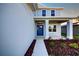 Inviting front entrance with blue door, manicured landscaping, and covered porch offering curb appeal at 6807 162Nd Pl, Parrish, FL 34219