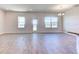 Spacious living room with wood-look tile floors, three windows and a door with pond views at 6807 162Nd Pl, Parrish, FL 34219
