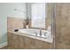 Bright bathroom featuring a bathtub and glass door shower, with natural light to create a tranquil retreat at 7710 S Desoto St, Tampa, FL 33616
