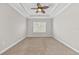 Spacious bedroom with carpeting, tray ceiling with fan, and natural light at 7710 S Desoto St, Tampa, FL 33616