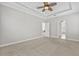 Spacious main bedroom featuring neutral colors, tray ceiling with ceiling fan, and doorways to other rooms at 7710 S Desoto St, Tampa, FL 33616
