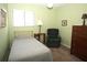 Bedroom with a ceiling fan, window, bedside table, and dark wood dresser at 8011 Peach Dr # 103, Tampa, FL 33637