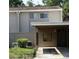 Townhouse exterior view with a covered carport area and neutral-toned siding, surrounded by greenery at 8011 Peach Dr # 103, Tampa, FL 33637