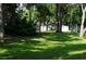 Exterior lawn view with mature trees and green grass at 8011 Peach Dr # 103, Tampa, FL 33637