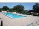 Community pool area featuring sparkling pools, lounge chairs, and shady trees at 8011 Peach Dr # 103, Tampa, FL 33637