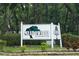 Community sign for Meadowood Condominiums surrounded by lush landscaping at 8011 Peach Dr # 103, Tampa, FL 33637