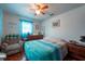Cozy bedroom with ceiling fan, wood floors, and a comfortable chair at 8305 75Th Pl, Seminole, FL 33777