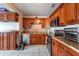 Modern kitchen with granite countertops, wooden cabinets, tile floors, and stainless steel appliances at 8305 75Th Pl, Seminole, FL 33777