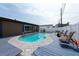 Backyard pool with a blue deck, white fence, lounge chairs and a small table at 8305 75Th Pl, Seminole, FL 33777