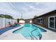 Inviting backyard pool with a white privacy fence and an adjacent patio area for outdoor enjoyment at 8305 75Th Pl, Seminole, FL 33777