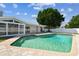 Picture of the in-ground swimming pool and back patio, enclosed lanai, and vinyl privacy fence at 8413 Lopez Dr, Tampa, FL 33615