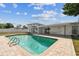 An in-ground swimming pool and enclosed lanai complement the backyard, framed by a white vinyl fence for privacy at 8413 Lopez Dr, Tampa, FL 33615