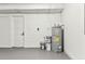 Unfinished basement area with concrete walls, a water heater, and a white door at 8413 Lopez Dr, Tampa, FL 33615