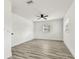 The bedroom has vinyl plank flooring, with a modern ceiling fan, two windows and white trim at 8413 Lopez Dr, Tampa, FL 33615