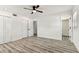 This bedroom features bright white walls, a ceiling fan, and wood-look flooring, creating a modern aesthetic at 8413 Lopez Dr, Tampa, FL 33615