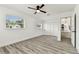 This bright bedroom features vinyl plank flooring, a ceiling fan and a closet, next to the kitchen at 8413 Lopez Dr, Tampa, FL 33615