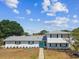 A charming home with a turquoise door, contrasted with white siding and dark shutters at 8413 Lopez Dr, Tampa, FL 33615