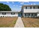 Charming two-story home with a well-manicured lawn and a striking, bright blue front door at 8413 Lopez Dr, Tampa, FL 33615