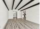 Spacious living area with wood-look floors, beamed ceiling and view to the entry at 8413 Lopez Dr, Tampa, FL 33615