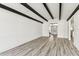 Open living area with wood-look floors and beamed ceiling, offering a modern, airy feel at 8413 Lopez Dr, Tampa, FL 33615