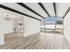 Living space with beam ceilings, view to the pool, and wood-look floors at 8413 Lopez Dr, Tampa, FL 33615