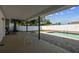 Covered patio with white metal table and chairs overlooks the sparkling in-ground pool and fenced yard at 8413 Lopez Dr, Tampa, FL 33615