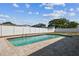 Beautiful rectangular in-ground swimming pool surrounded by a brick paver patio and a white privacy fence at 8413 Lopez Dr, Tampa, FL 33615