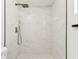 Close-up of shower, with a rainfall showerhead and white, marble-look tile at 8413 Lopez Dr, Tampa, FL 33615