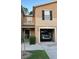 Inviting two-story townhome with a one-car garage, manicured lawn, and shaded front entry at 8423 Edgewater Place Blvd, Tampa, FL 33615