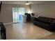 Open living room featuring tile flooring and a sliding glass door with access to the outside at 8423 Edgewater Place Blvd, Tampa, FL 33615