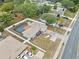 Aerial view of a home with a screened-in pool, a spacious yard, and proximity to a well-trafficked road at 9107 Spring Hill Dr, Spring Hill, FL 34608