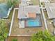 Aerial view showcasing a fenced backyard with a private screened pool, surrounded by a well-kept lawn at 9107 Spring Hill Dr, Spring Hill, FL 34608