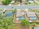 Overhead view of a property featuring a screened pool, well-maintained lawn and a convenient location near a road at 9107 Spring Hill Dr, Spring Hill, FL 34608
