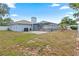Exterior view of the home with a patio, screened-in pool area, and a spacious backyard at 9107 Spring Hill Dr, Spring Hill, FL 34608