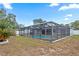 Expansive backyard with a screened-in pool area and ample space for outdoor activities at 9107 Spring Hill Dr, Spring Hill, FL 34608