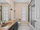 Bathroom featuring a dark vanity with marble countertop, and glass-enclosed shower at 9107 Spring Hill Dr, Spring Hill, FL 34608