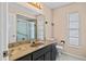 Bathroom featuring a dark vanity with marble countertop, a large mirror, and natural light at 9107 Spring Hill Dr, Spring Hill, FL 34608