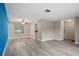Open living room with modern flooring and neutral paint, featuring a bright blue accent wall at 9107 Spring Hill Dr, Spring Hill, FL 34608