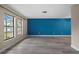 Bright living room with a vibrant blue accent wall and modern, light-colored flooring at 9107 Spring Hill Dr, Spring Hill, FL 34608