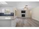 Open-concept living space with a fireplace, ceiling fan and sliding glass door to the outdoor patio area at 9107 Spring Hill Dr, Spring Hill, FL 34608