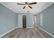 Spacious main bedroom with light wood flooring, light blue walls, a ceiling fan, and a closet at 9107 Spring Hill Dr, Spring Hill, FL 34608