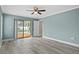 Bright main bedroom with light blue walls, light wood flooring, and sliding glass doors to the pool area at 9107 Spring Hill Dr, Spring Hill, FL 34608
