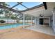 Screened-in pool area with tiled patio and ceiling fan, perfect for outdoor entertaining and relaxation at 9107 Spring Hill Dr, Spring Hill, FL 34608