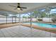 View of the screened in pool and patio area with tiled flooring and ceiling fan at 9107 Spring Hill Dr, Spring Hill, FL 34608