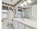 Charming bathroom with decorative border, white vanity, and glass-enclosed shower at 9219 Irondale Ln, Hudson, FL 34667