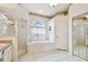Bathroom with glass enclosed shower, garden tub with window, and large mirror at 9219 Irondale Ln, Hudson, FL 34667