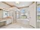 Bathroom featuring a large garden tub, separate shower, and vanity area with lots of natural light at 9219 Irondale Ln, Hudson, FL 34667