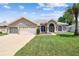 Charming single-story home featuring a manicured lawn, arched windows, and a spacious two-car garage at 9219 Irondale Ln, Hudson, FL 34667